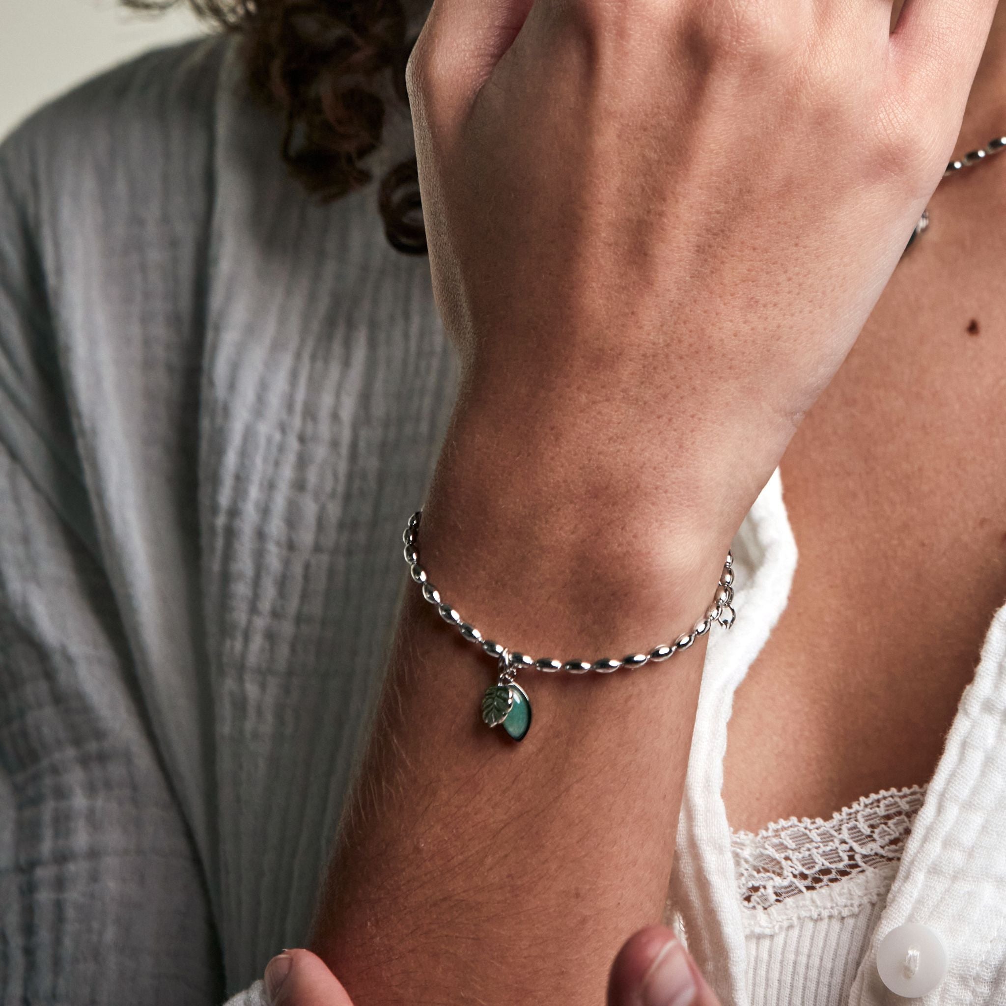 armband med en grön sten och ett blad i hänge