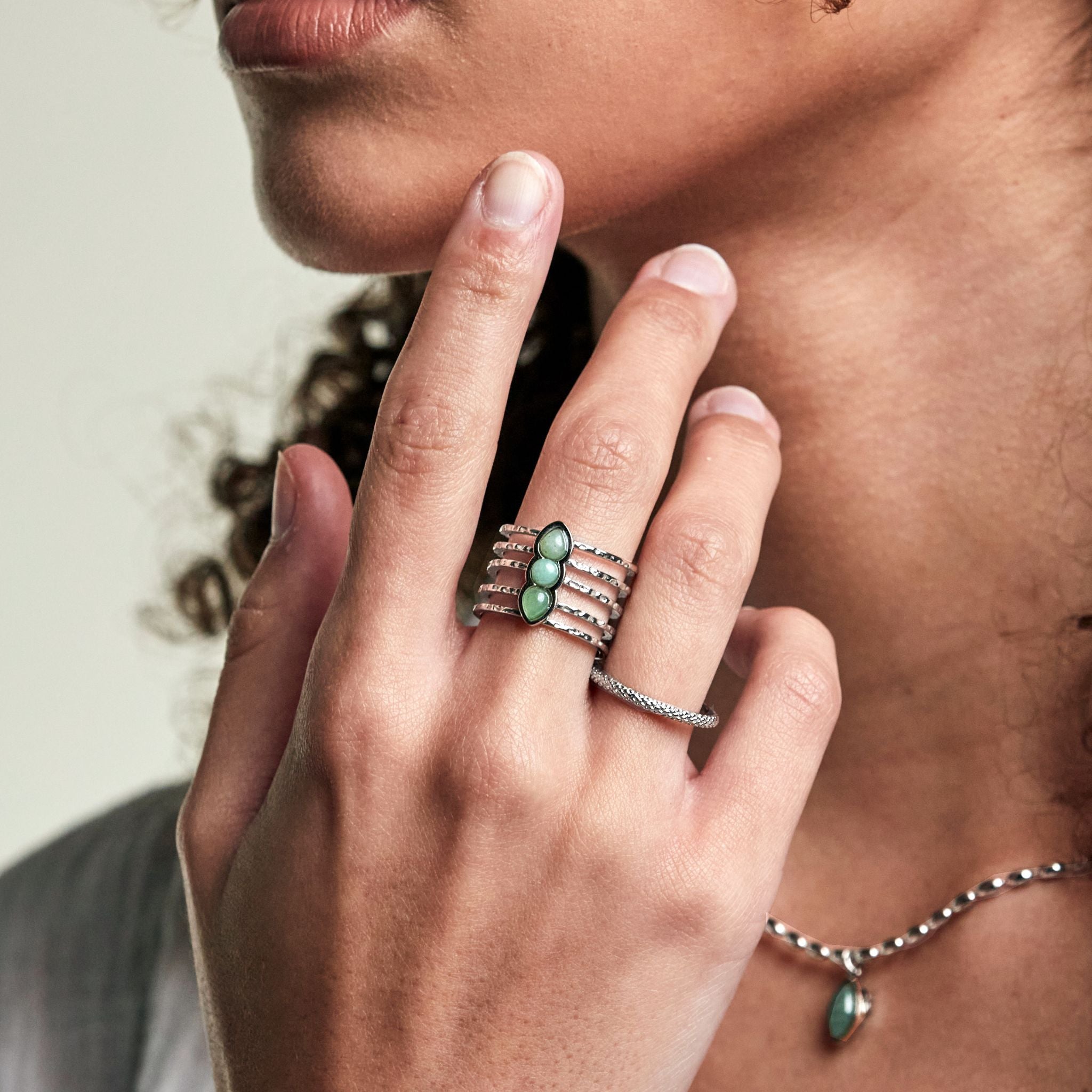 ring i rostfritt stål med gröna stenar